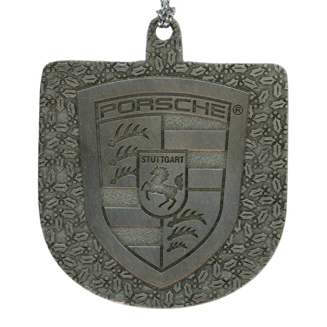 Metallic Porsche emblem on a white background