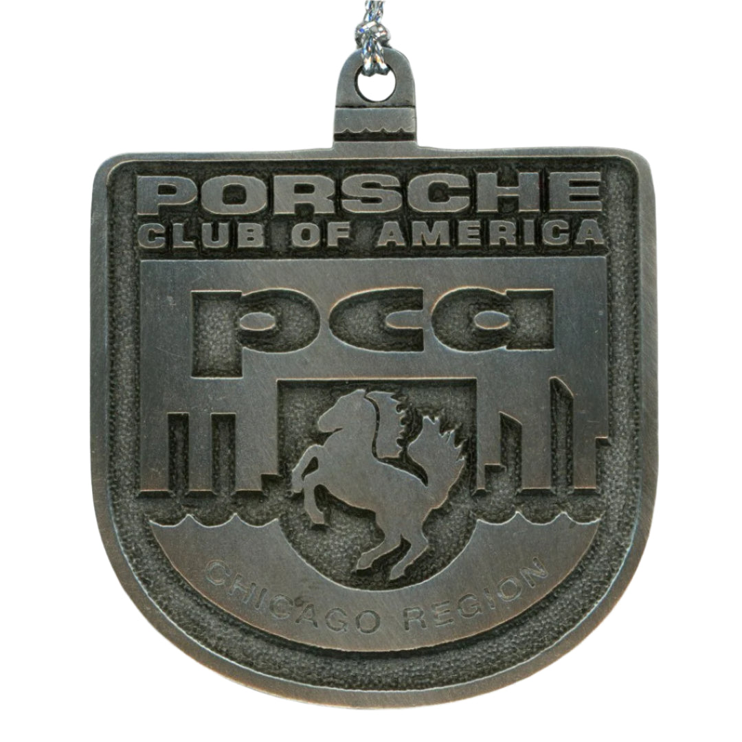 Metallic Porsche Club of America badge with horse logo on a white background